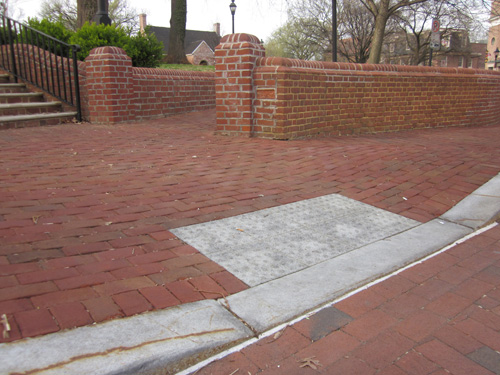 Capitol: Three photos show a sidewalk in front of a wide stairway with a retaining wall about 4 feet high on each side of the stairs.  The street, sidewalk, wall stairs, and ramp going around the stairs are all made of red brick.  The brick slopes down to the street to form a curbramp about 4 feet wide.  The detectable warning is made out of two rows of 4 white cement tiles which are each about a foot square with 64 truncated domes (6 on each side of the tile).